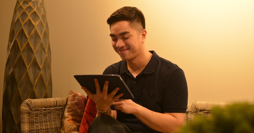 Man smiling while using his tablet